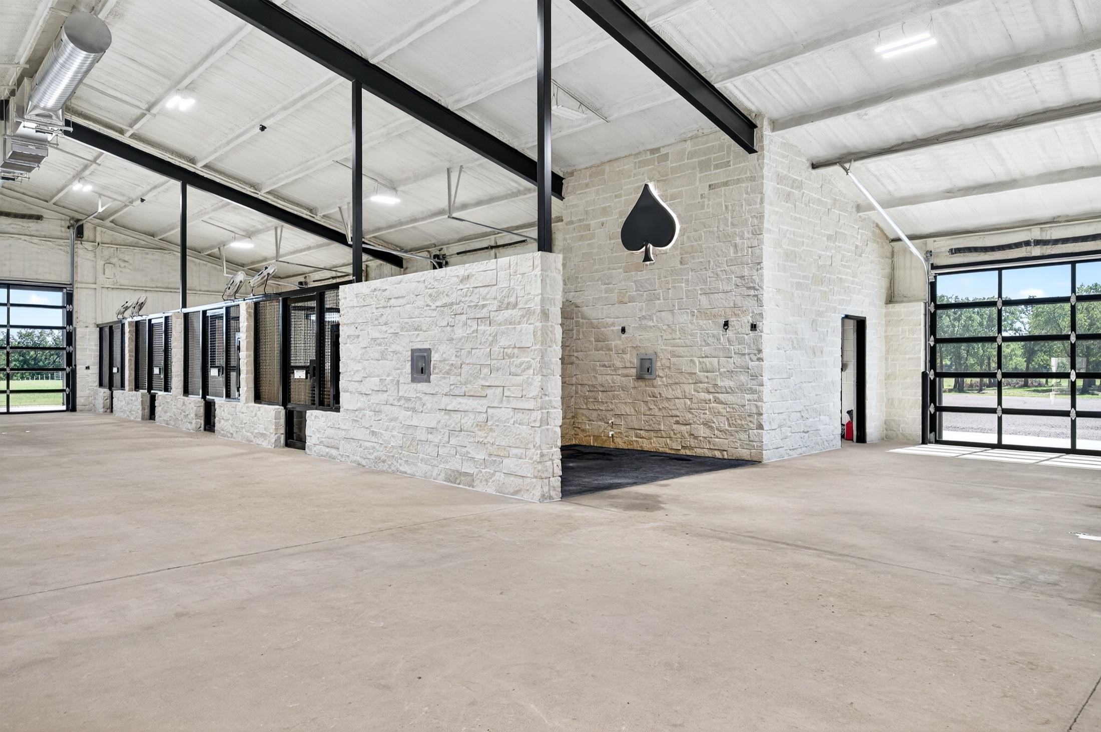 Inside the climate-controlled stallion barn at Solo Select, with stone stalls and the spade crest.