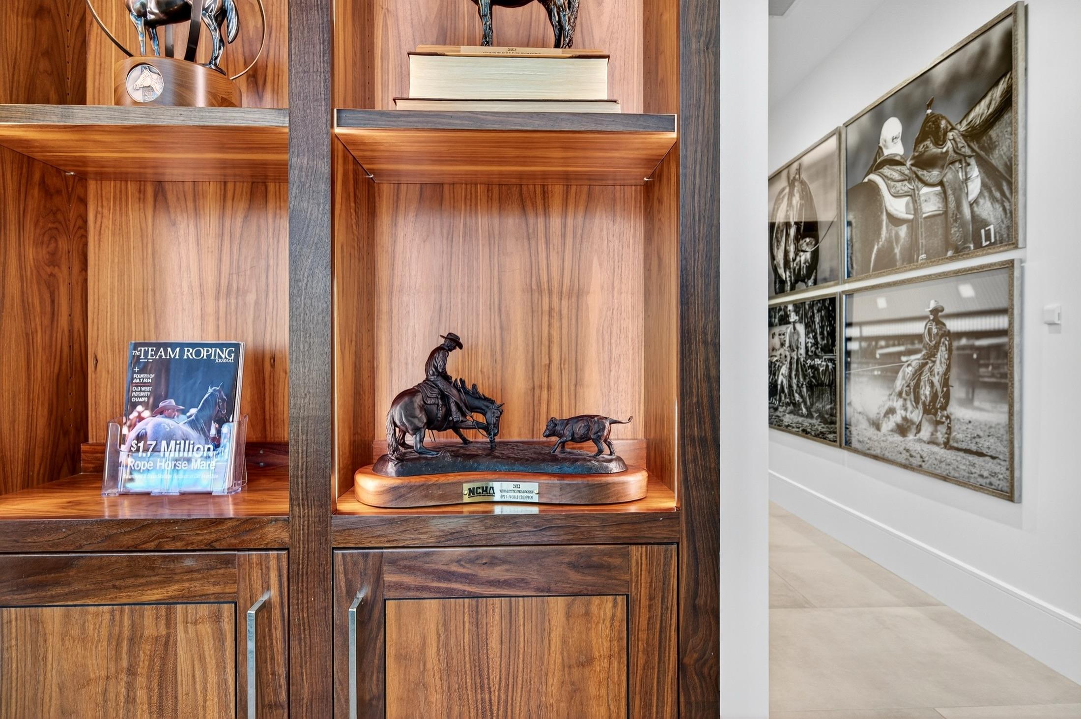 Trophy shelves and framed photography lining a hallway in the client lounge