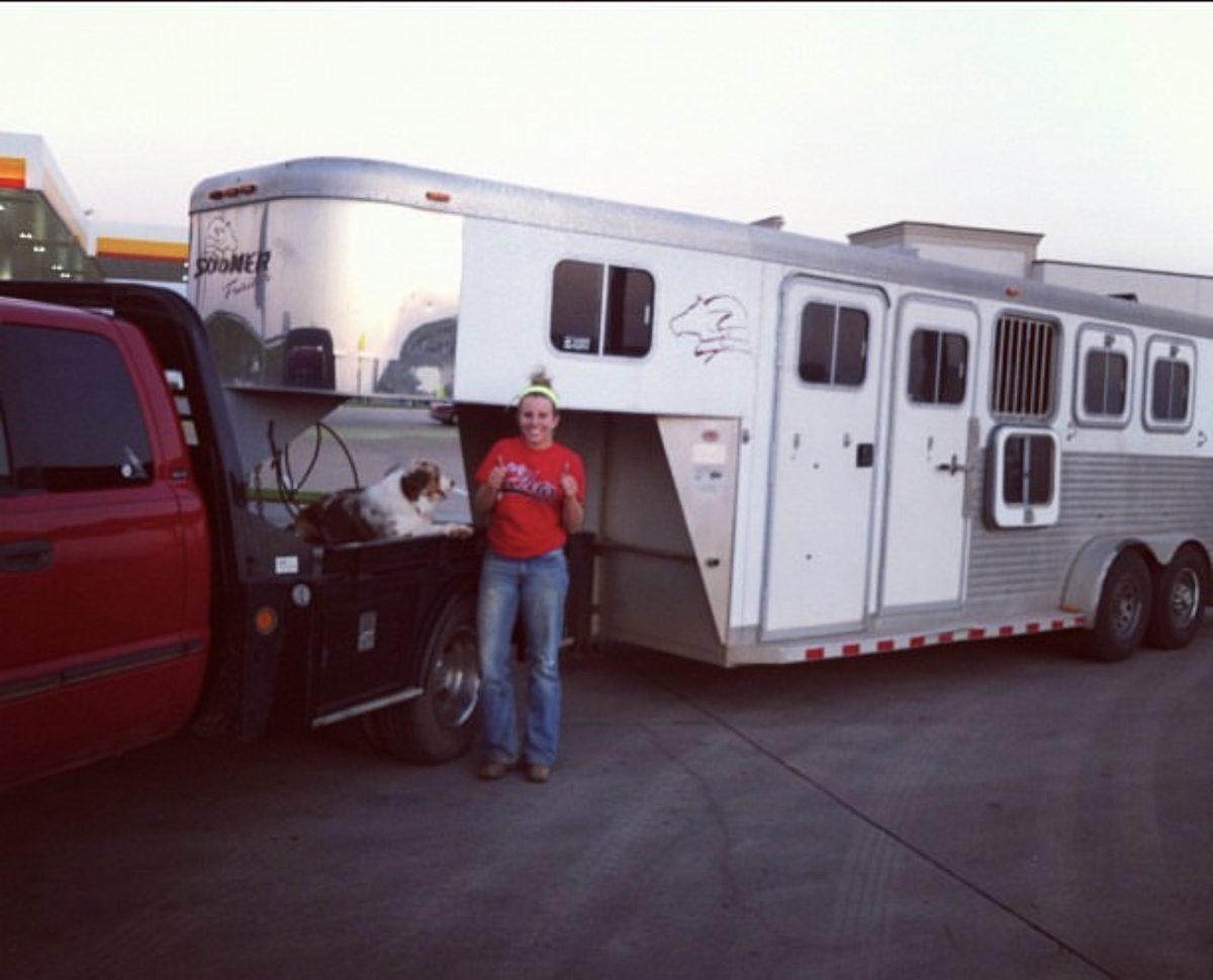 Nineteen-year-old Melanie giving two thumbs up beside her first horse trailer