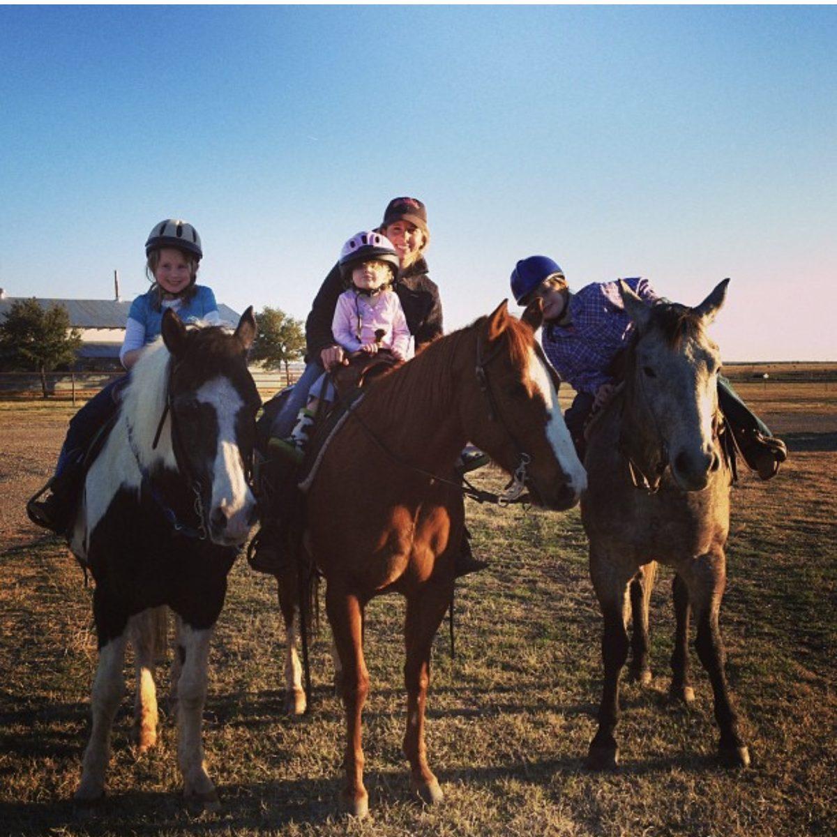 Melanie riding with three of her young lesson students