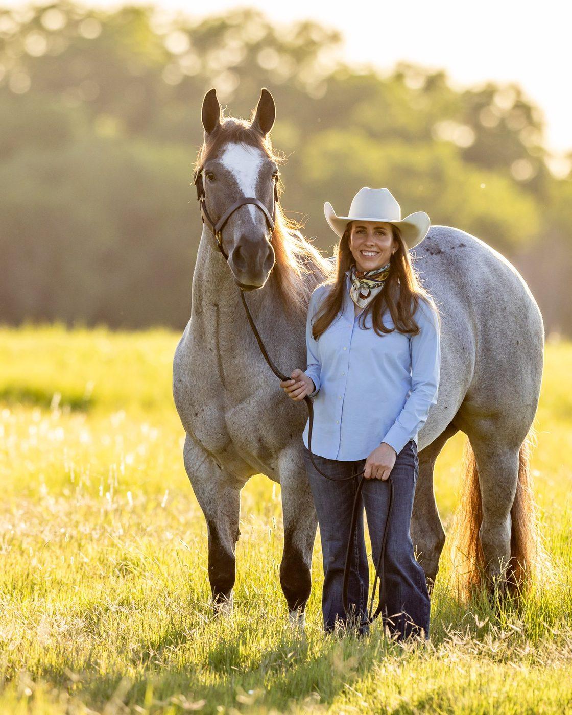 Melanie Smith, founder of Solo Select Horses, with a gray horse in a Texas pasture
