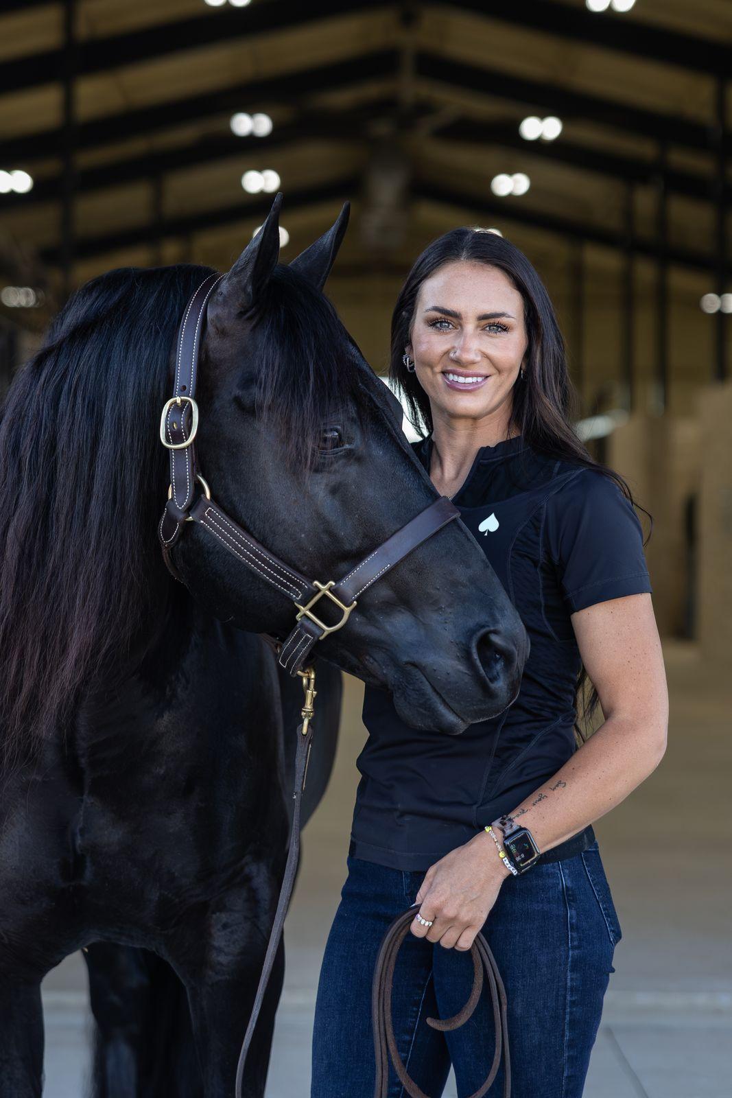Dr. Hannah Carter, DVM, standing with a horse in the barn aisle at Solo Select